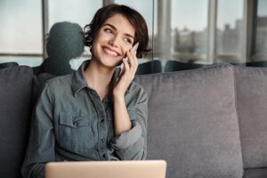 woman with short hair smiles and talks on the phone about the benefits of dialectical behavior therapy on her mental health